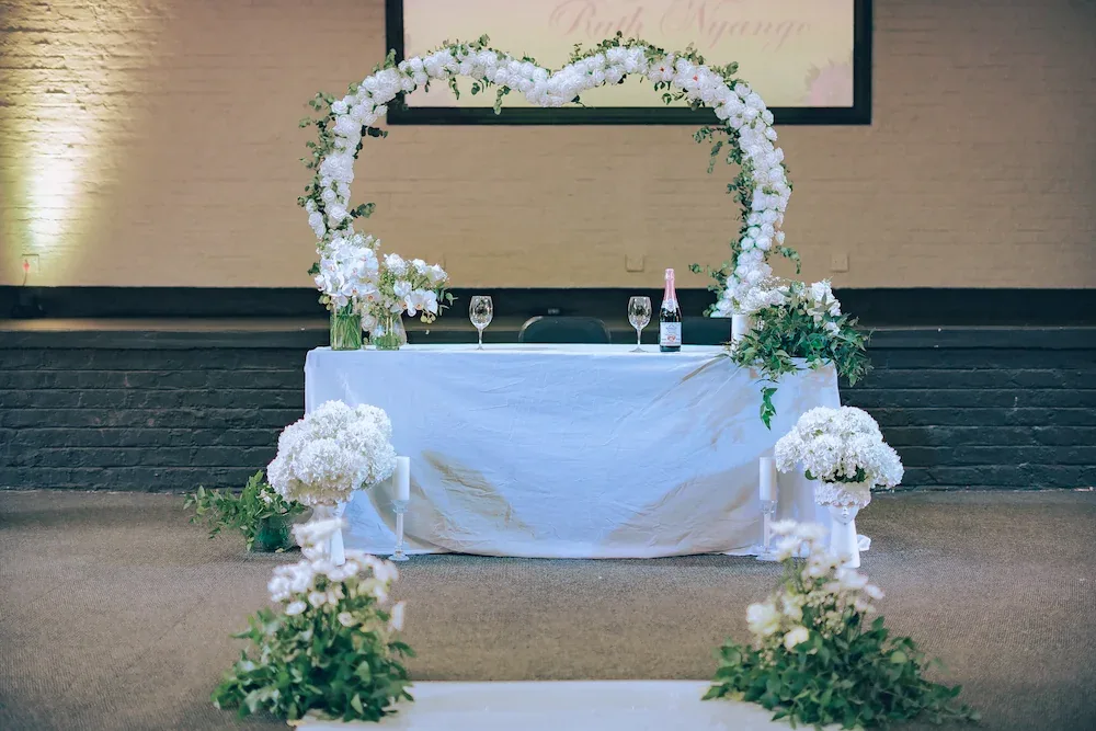 Heart-shaped floral arch backdrop for a wedding ceremony