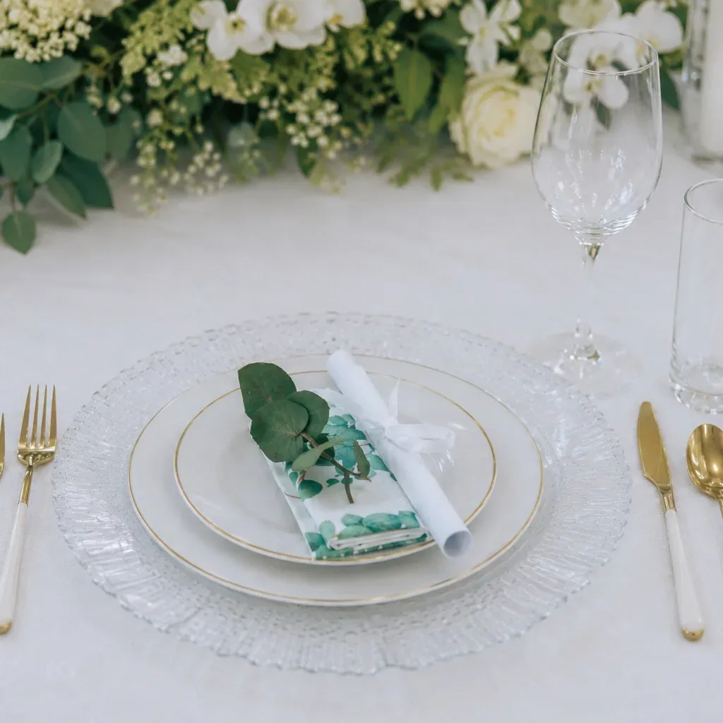 Wedding place setting with greenery, candlelight and coordinated table details