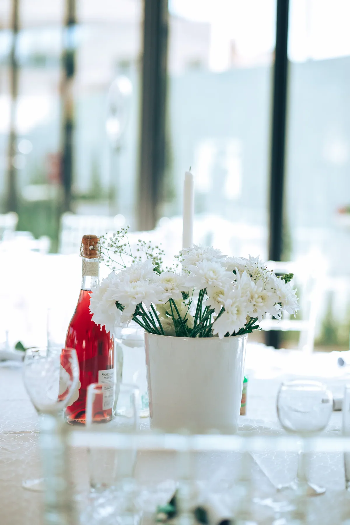 Wedding reception table with white florals and coordinated place settings