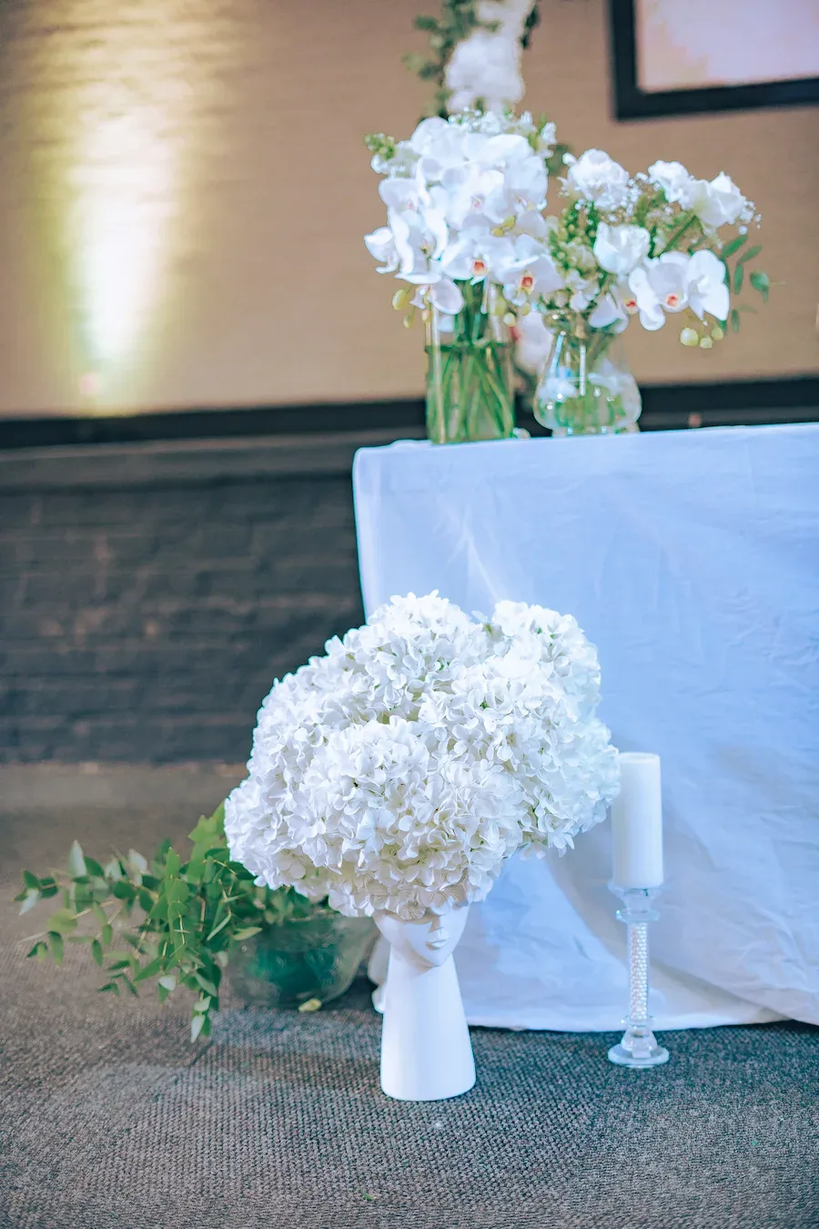 White floral arch and draped table prepared for a wedding ceremony